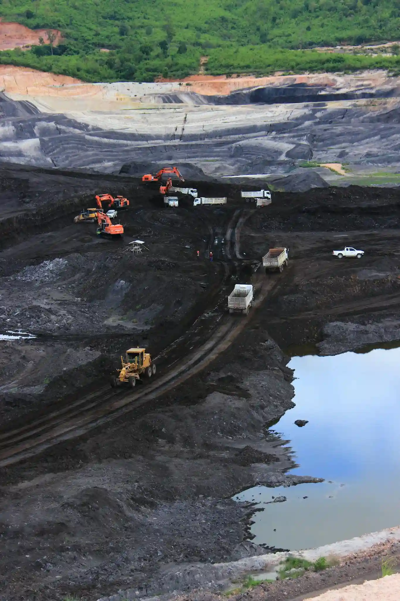 Aerial photograph showcasing machinery working in a vast open-pit mining site. They all have the Adblue / DEF Delete emulator fitted to the excavators as you can see everyone is busy on working machinery